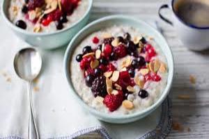 A bowl of oatmeal with berries and almonds.