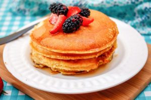 A stack of pancakes with berries on top.