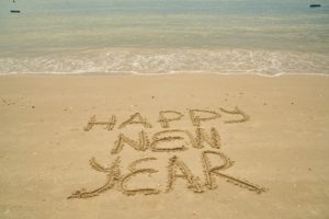 A sandy beach with the words happy new year written in it.